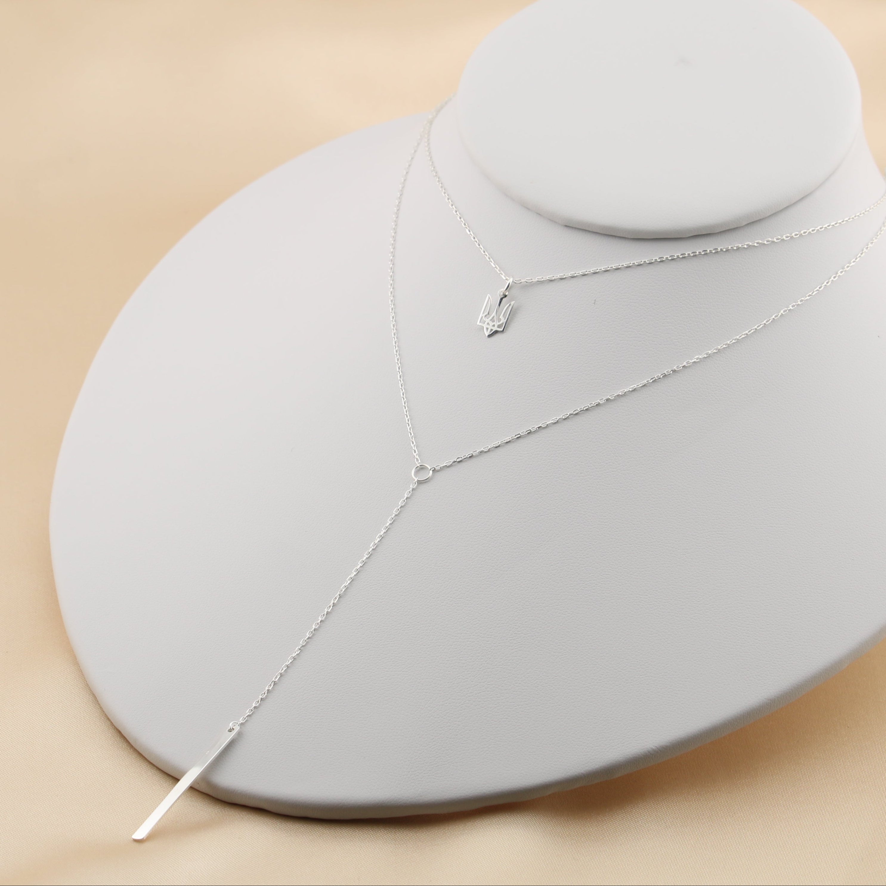Trident necklace layered with a dangling chain