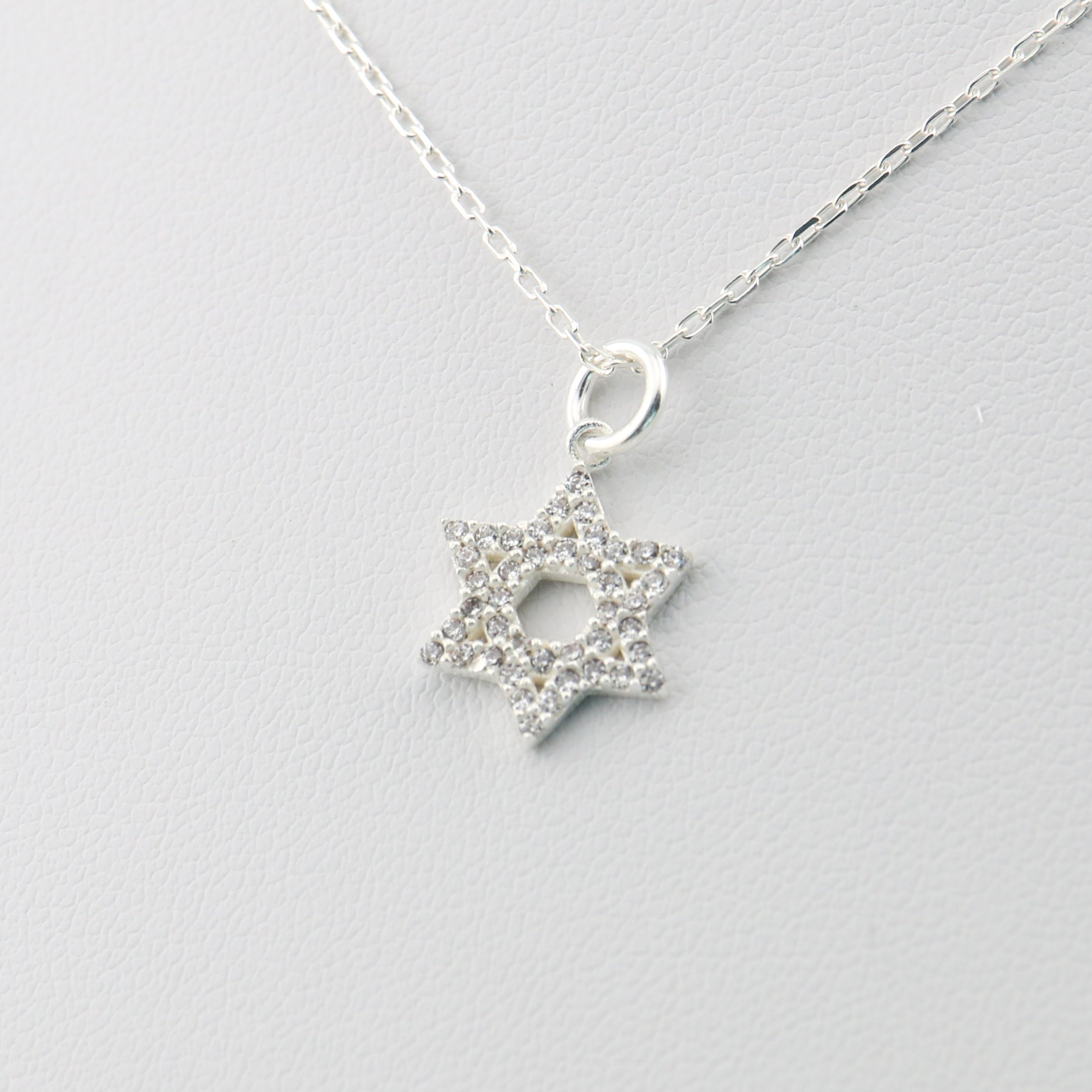 Silver necklace with a star-of david pendant on a light gray background