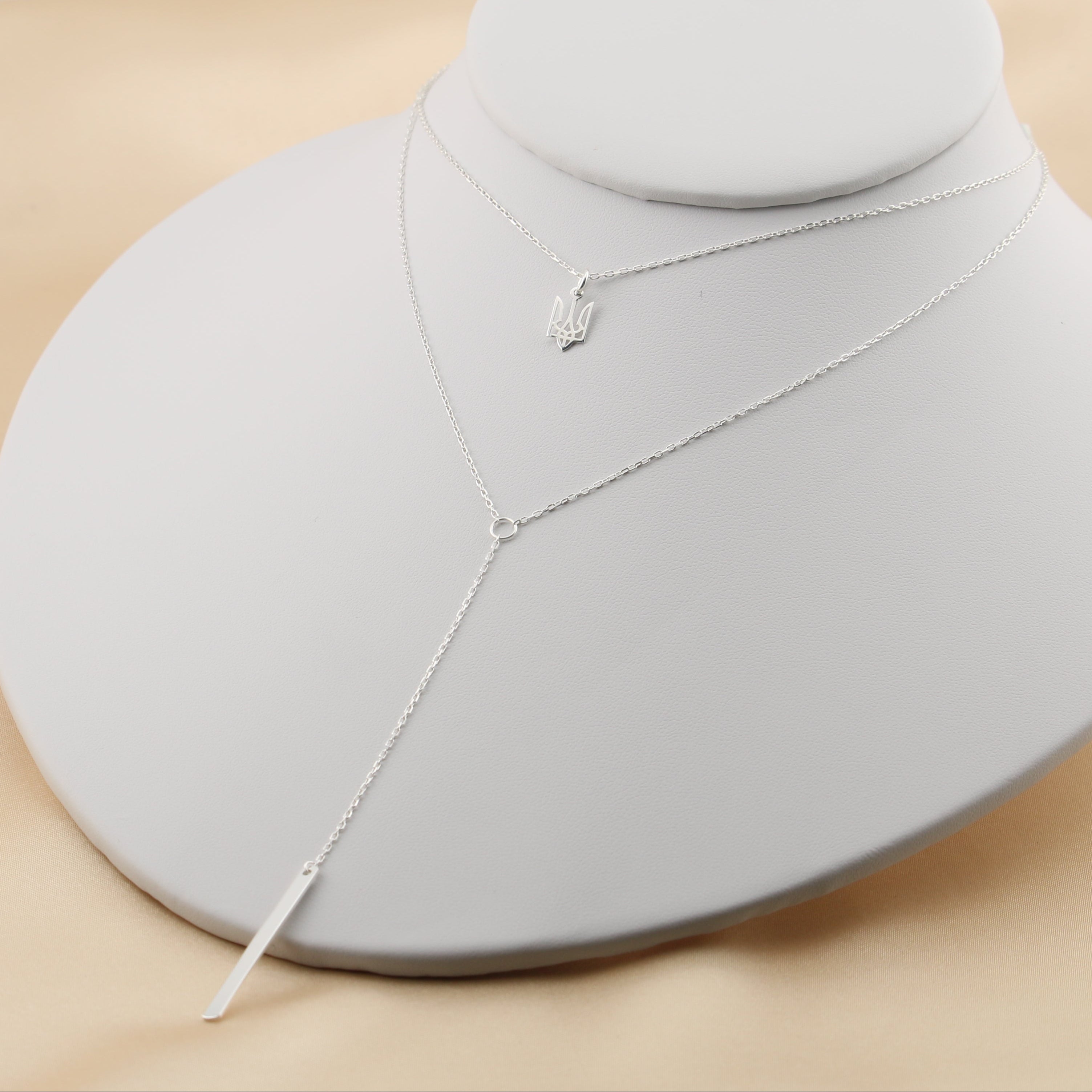 Trident necklace layered with a dangling chain